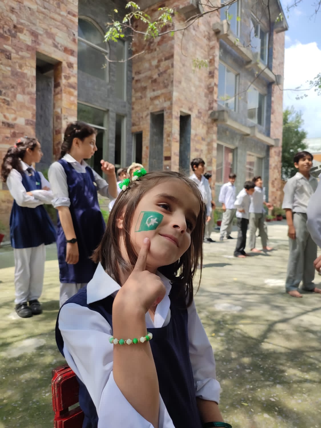 A Present Times student with a Pakistan flag painted on her cheek at the Independence Day assembly